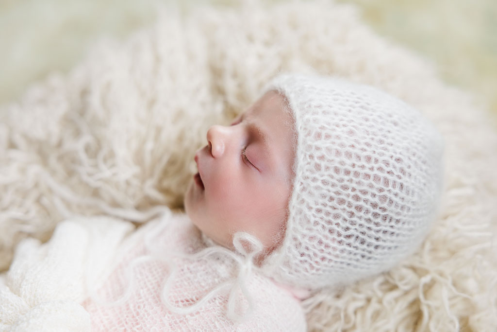 Newborn baby peacefully nestled in a soft blanket, captured by Faith Rand Photography, renowned Middle Georgia family, maternity, and newborn photographer.